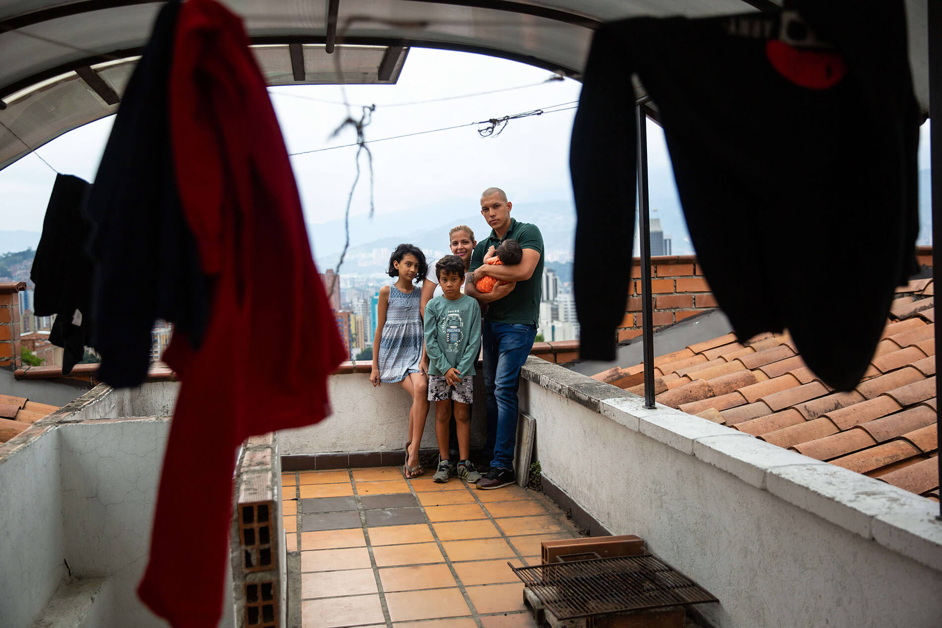 A family stands on the roof of their apartment building.