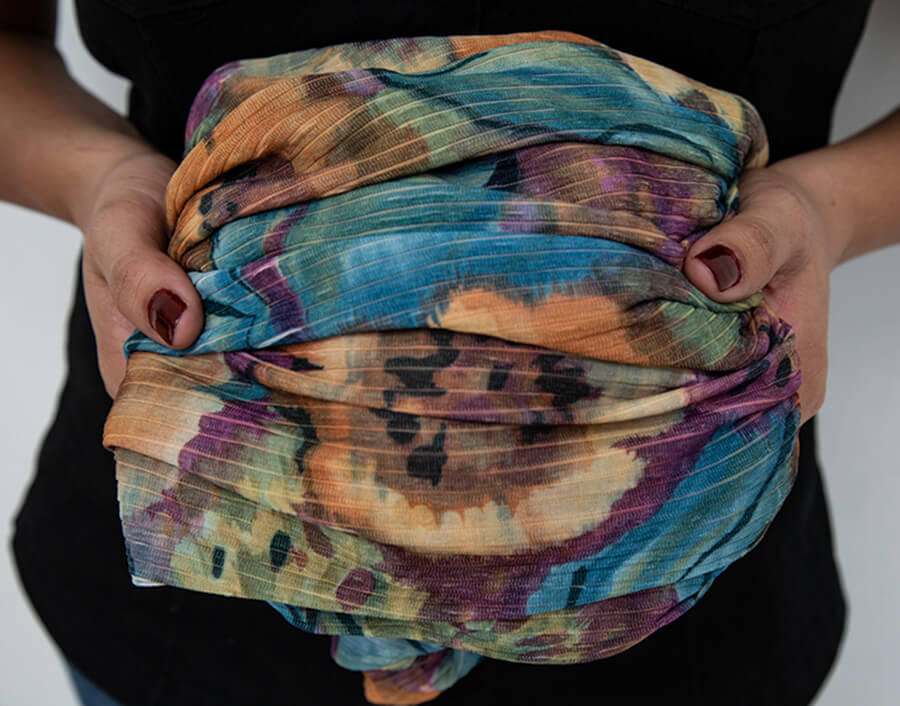 A folded dress is held in a woman’s hands