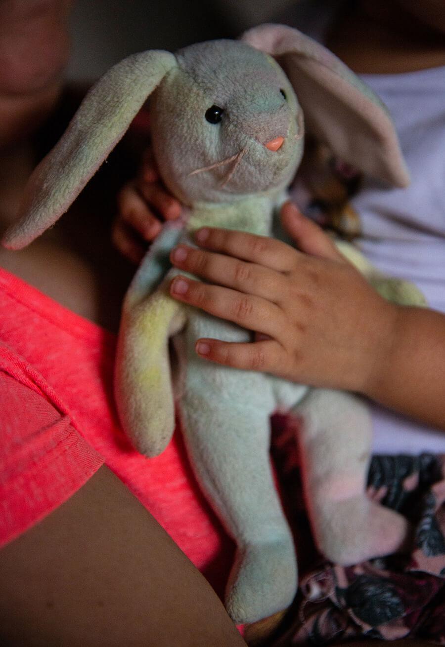 A close up of a stuffed animal bunny in a child’s hands