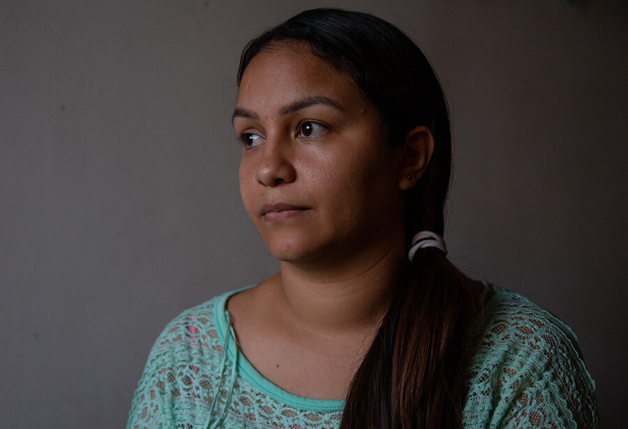 A woman sits for a portrait and looks into the distance